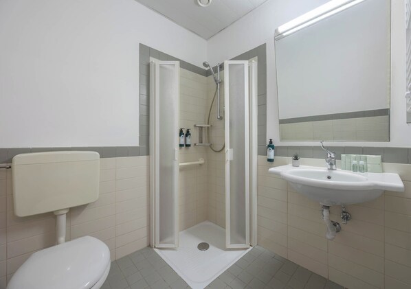 Habitación básica doble | Baño | Regadera, pantuflas, toallas, jabón 