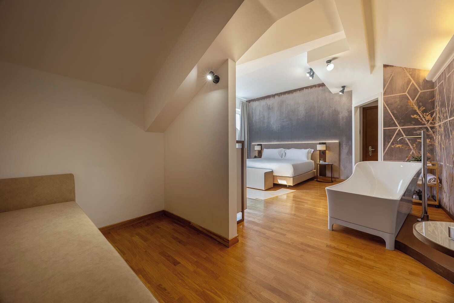 Une chambre d’hôtel moderne dotée d’un grand lit, d’un coin salon et d’une baignoire.