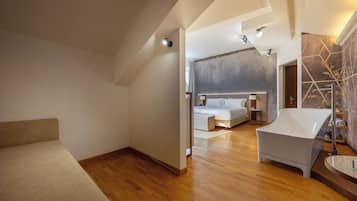 Une chambre d’hôtel moderne dotée d’un grand lit, d’un coin salon et d’une baignoire.