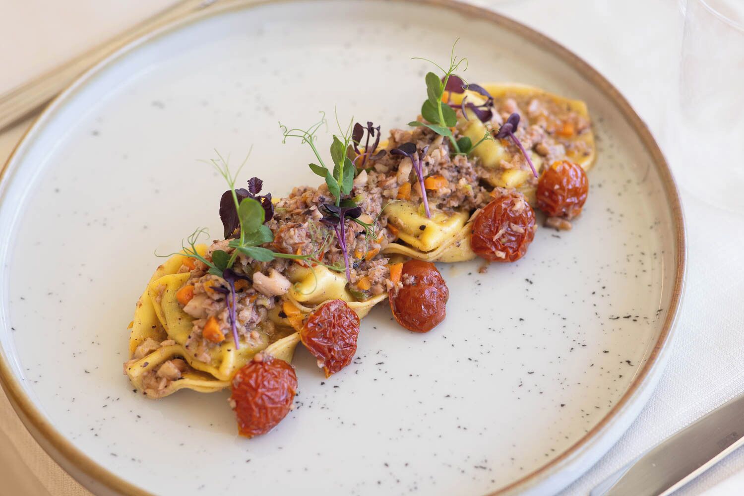 A dish with pasta, meat, and vegetables on a plate.