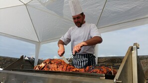 A chef grilling meat under a white canopy. - Cape Cornwall golf & Leisure (Penzance)