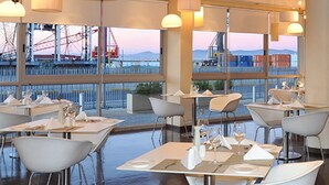 A modern restaurant with tables and chairs arranged for dining. - 410 Harbour Bridge (Cape Town)
