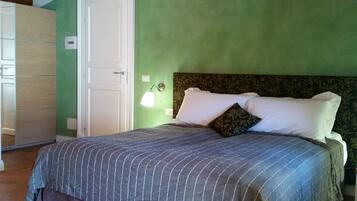 Une chambre à coucher avec un lit, une table de chevet, une lampe et une armoire.