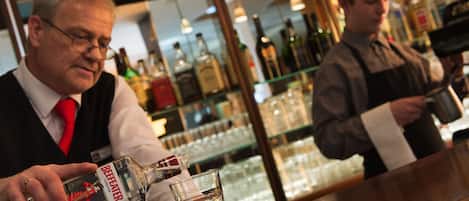 A bar area with a bartender preparing a drink.