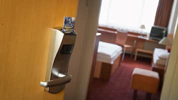 Ein Hotelzimmer mit Bett, Schreibtisch, Stuhl und kleinem Tisch.