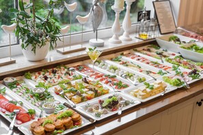 A buffet with various food items and a potted plant. - Villa Atlantis (Kolobrzeg)