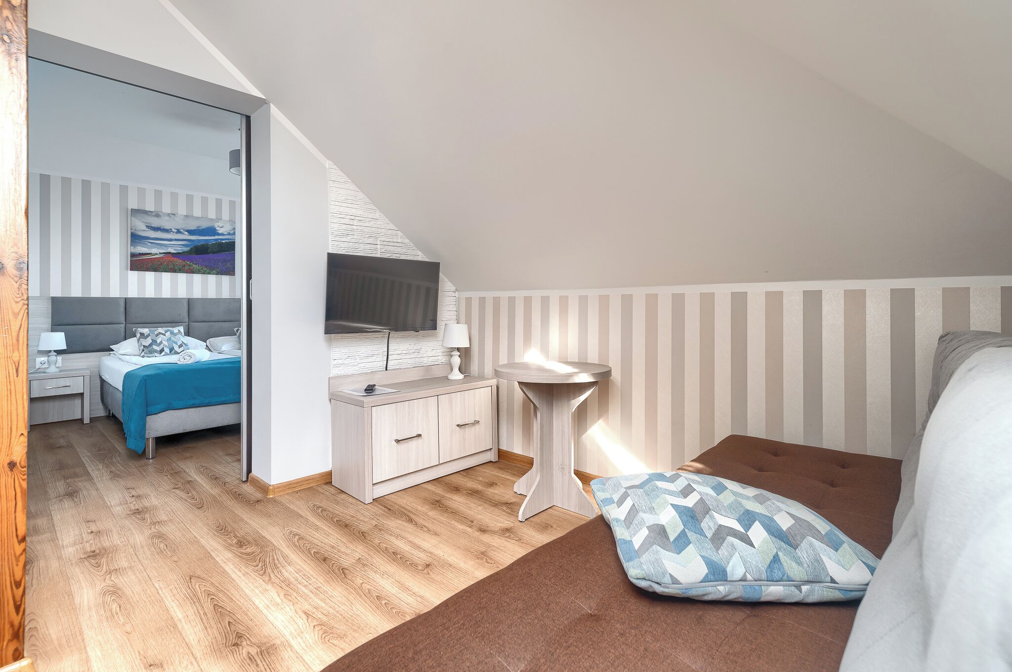 Une chambre à coucher avec un lit, une table de chevet, une lampe et un tableau au mur.