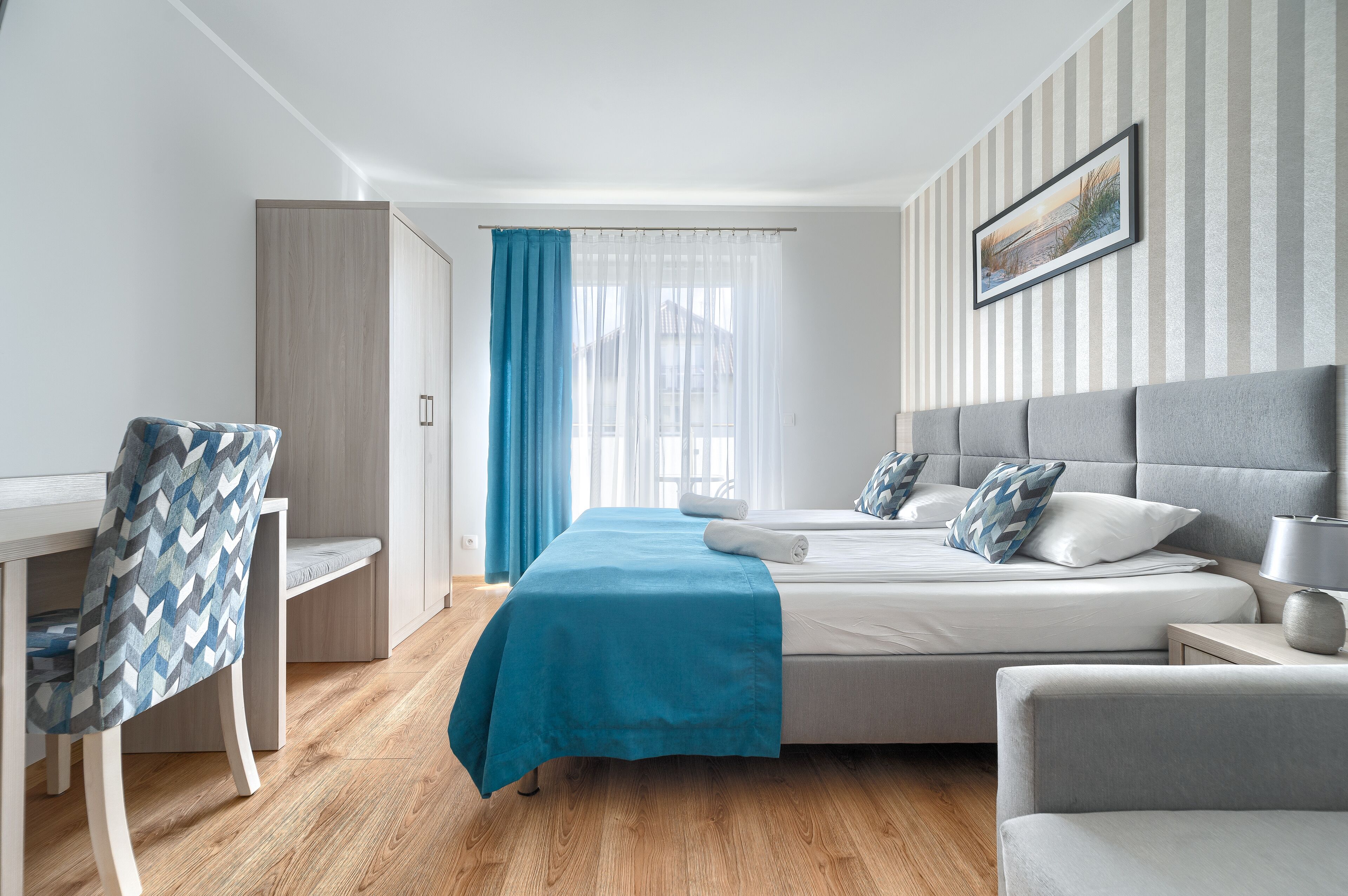 A modern bedroom with a bed, a desk, and a chair.