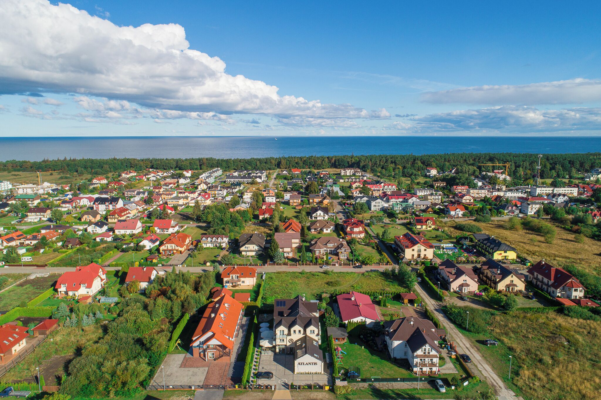 Een woongebied met huizen en een groot wateroppervlak op de achtergrond.