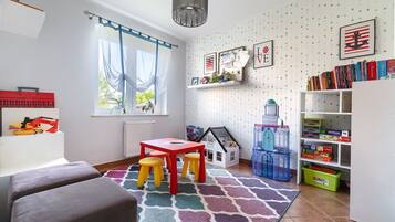 Children can play and learn in this inviting space with a playhouse, bookshelves, and a table for creative play.