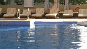 A pool area with lounge chairs and a tiled edge. - Gulf Suites Hotel Amwaj (Amwaj Islands)
