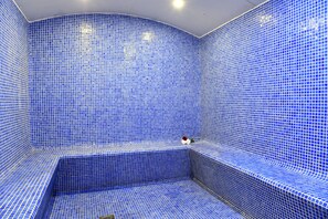 A room with blue-tiled walls and a curved bench. - Gulf Suites Hotel Amwaj (Amwaj Islands)