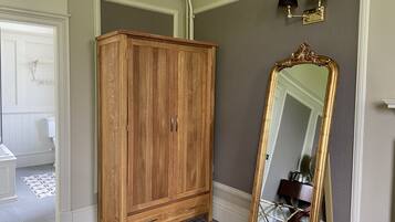 Una habitación con un armario de madera, un espejo grande y un suelo a cuadros.