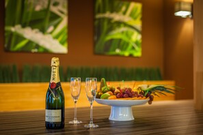A bottle of Moët & Chandon champagne, two glasses, and a fruit platter on a table.