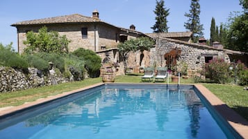 Relax in a serene, setting surrounded by lush greenery and a tranquil pool.