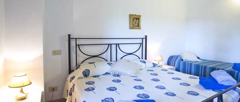 Una camera da letto con un letto, comodini e un tavolino di servizio.