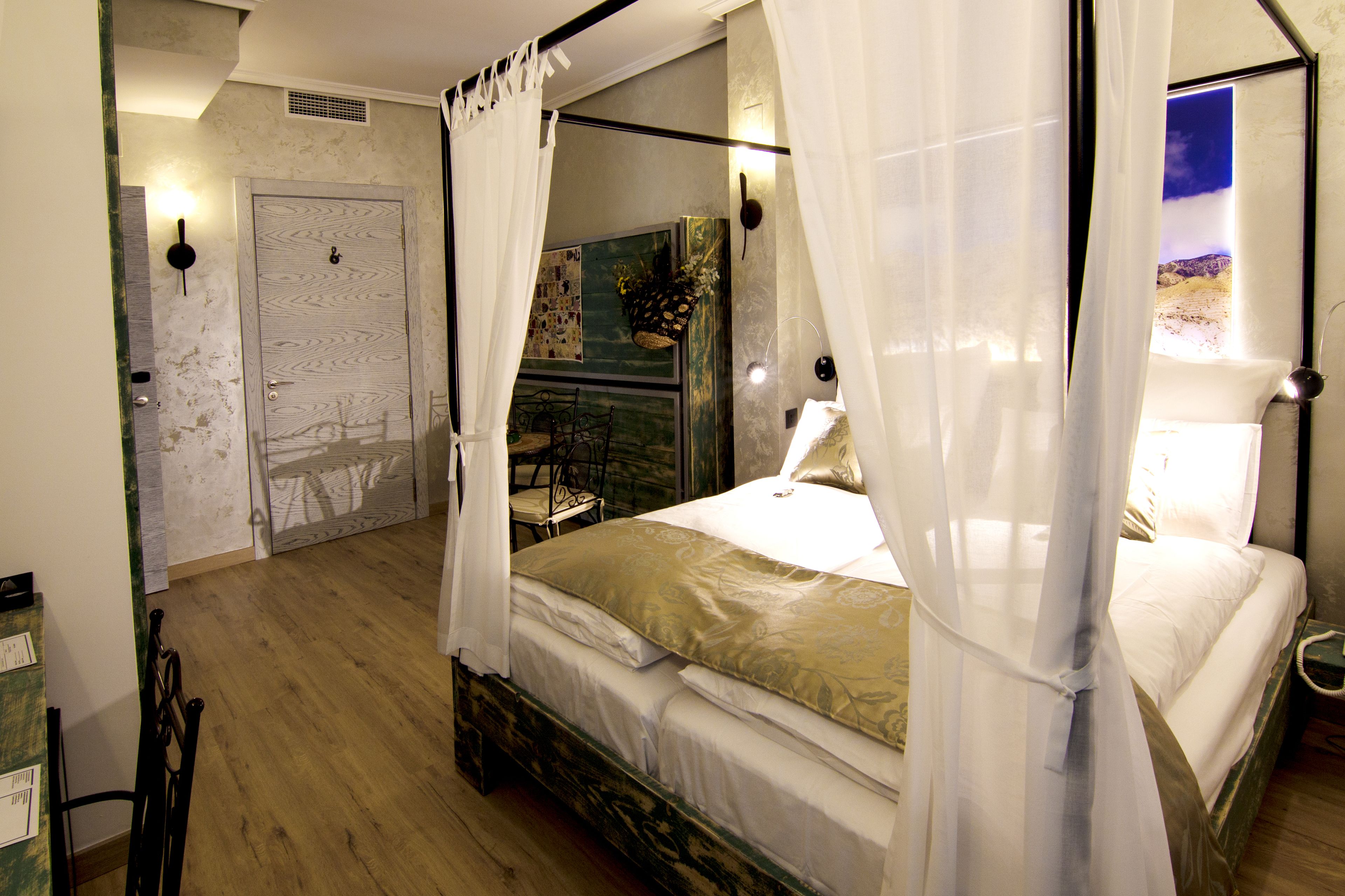 Quarto com uma cama de dossel, mesa de cabeceira, cadeira e porta com interruptor de luz.