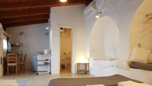 Un dormitorio con cama, mesita de noche y vistas al baño.