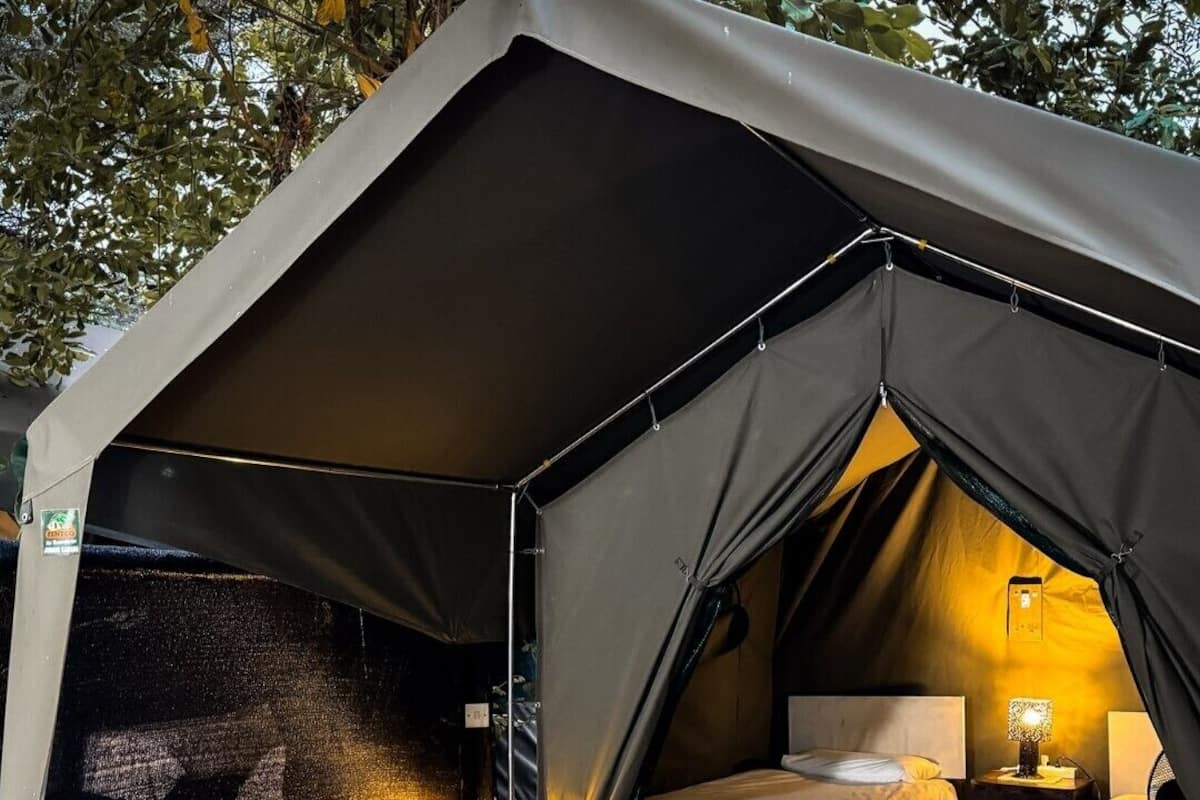 Una carpa con dos camas, una mesa y una silla en su interior.
