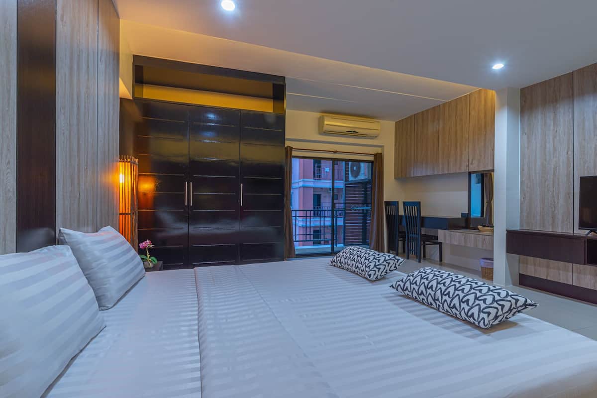 Une chambre d’hôtel moderne avec un grand lit, un bureau et une vue sur l’extérieur.