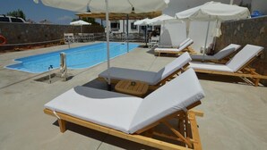A rooftop pool area with lounge chairs and umbrellas. - Koukounari Rooms (Agistri)