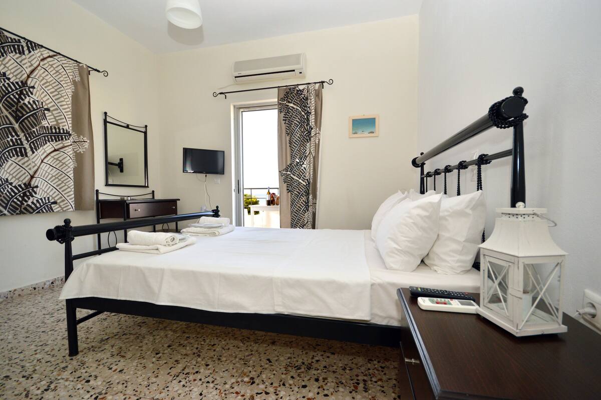 A neatly arranged bedroom with a bed, bedside table, and a TV.
