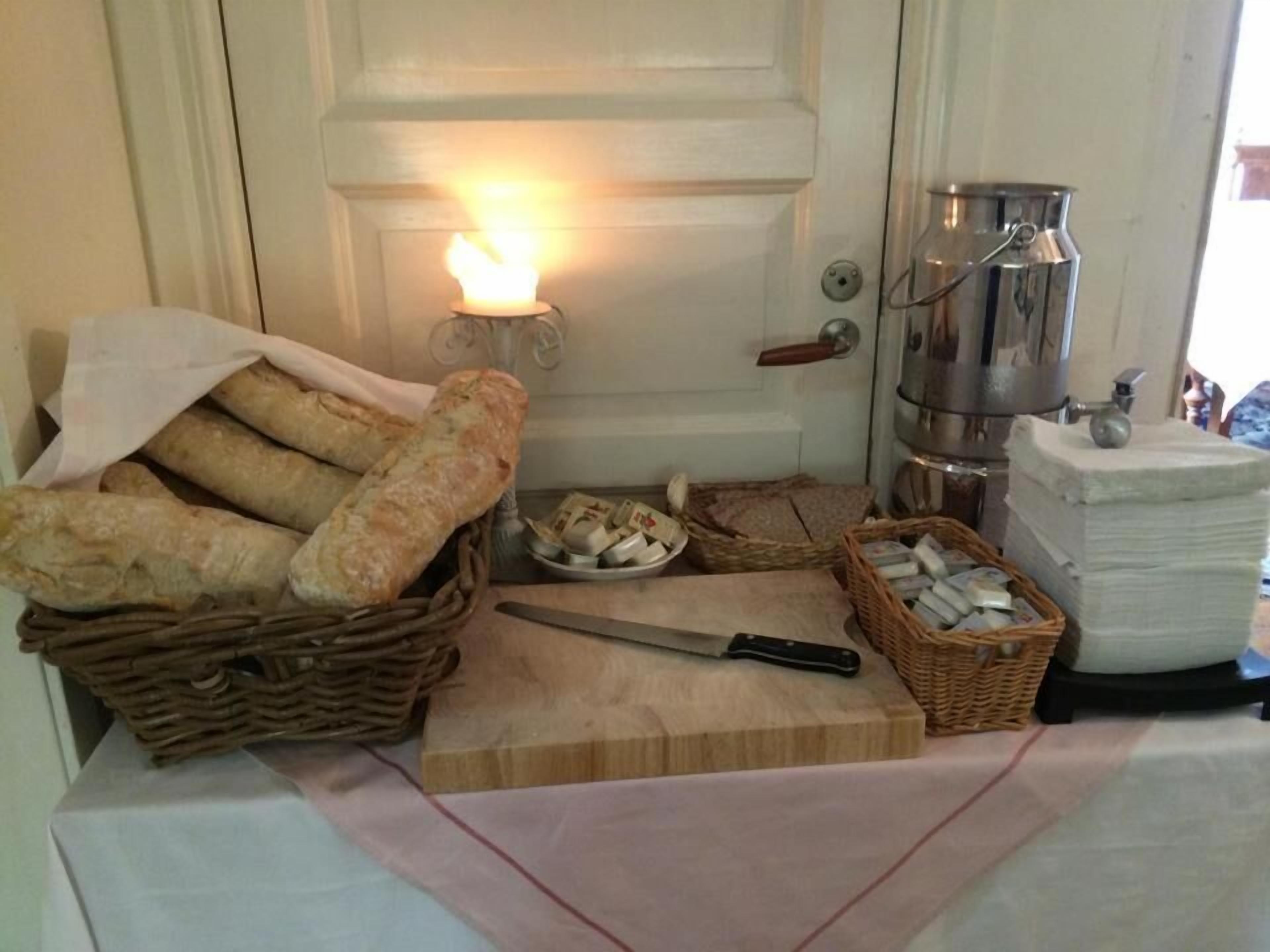 Een keukenblad met brood, een mes en een broodoos.