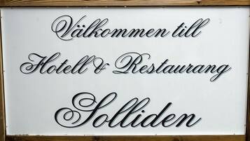 Un letrero con el texto 'Välkommen till Hotel & Restaurant Solliden' en una caligrafía decorativa.