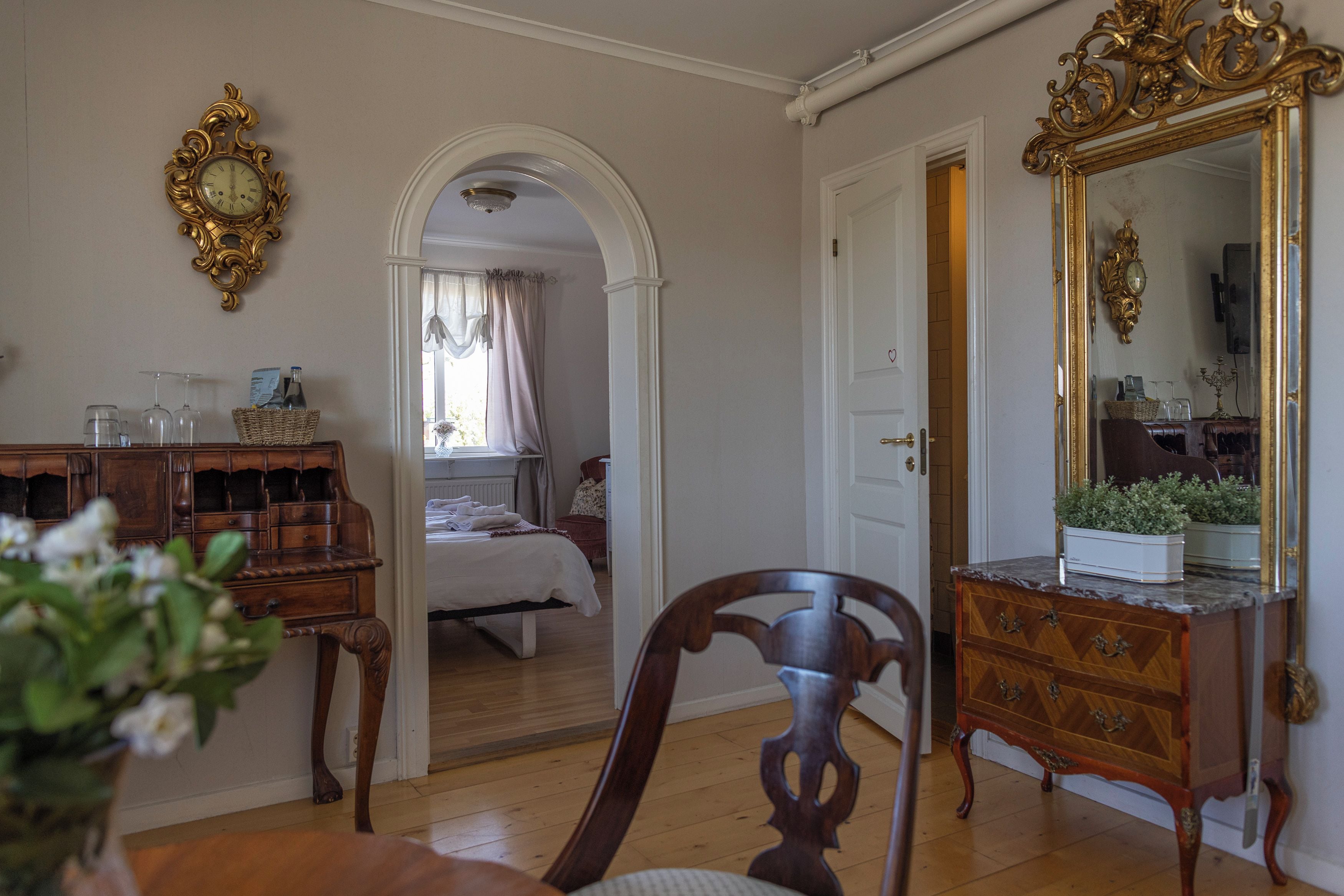 Una habitación con un aparador de madera, un espejo y una cama con ventana.