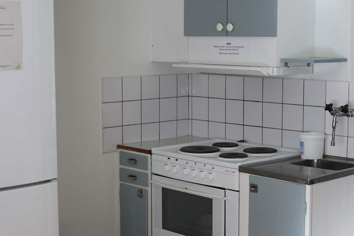 A compact kitchen with a refrigerator, stove, oven, and a small sink.