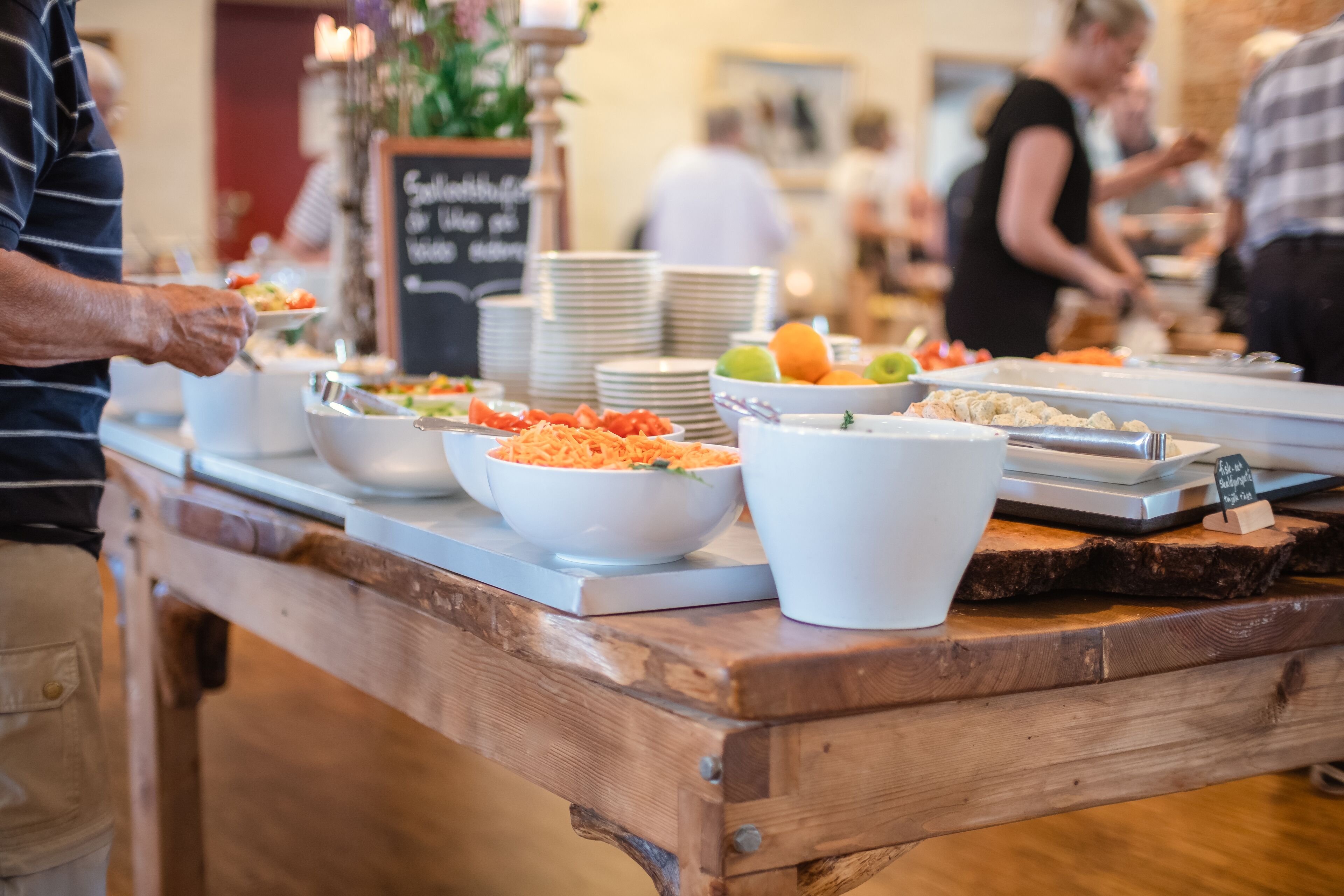 Una mesa de madera con diversos alimentos y cuencos en un montaje tipo buffet.