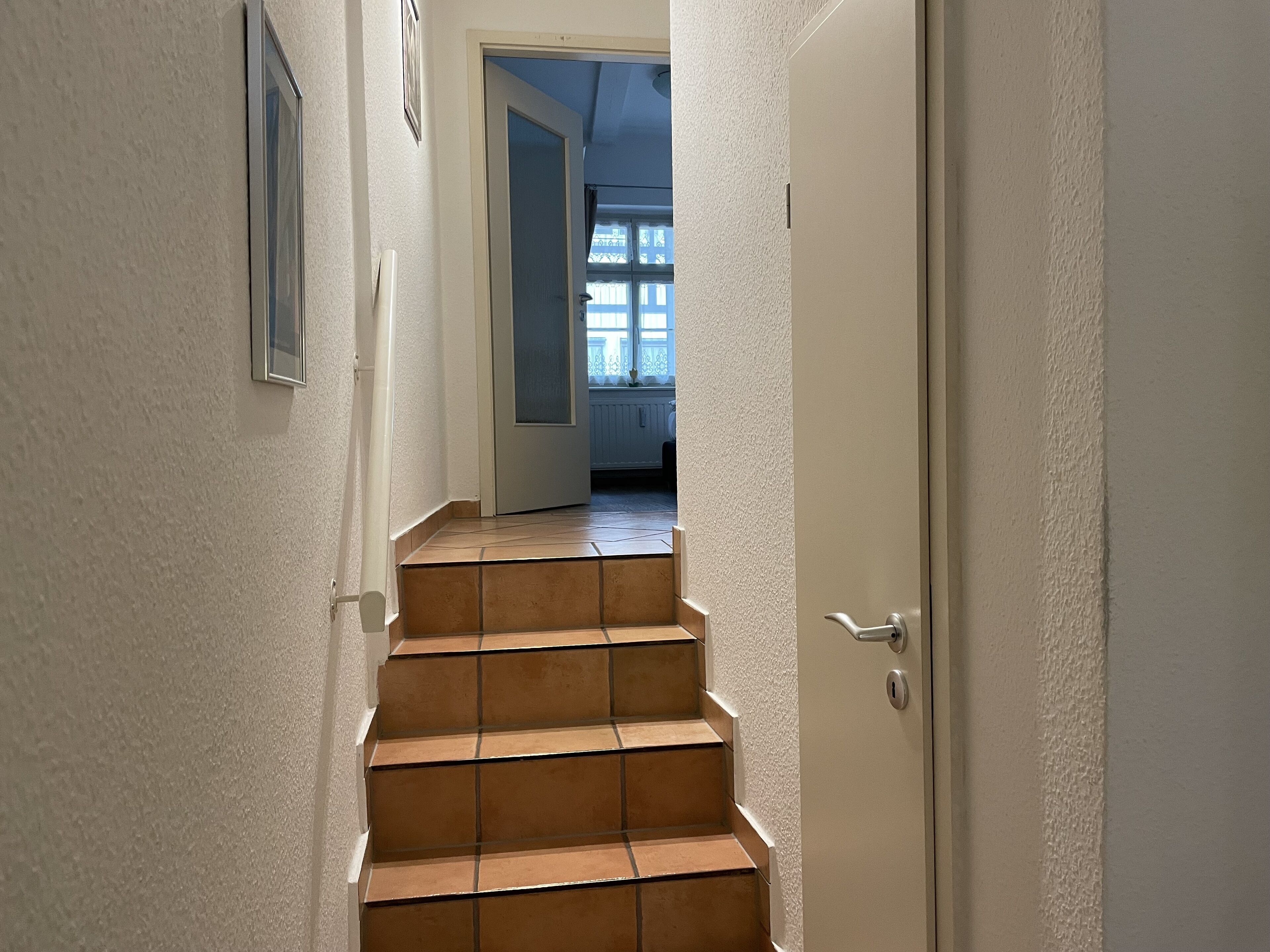 Een trap die leidt naar een kamer met een deur aan de bovenkant.