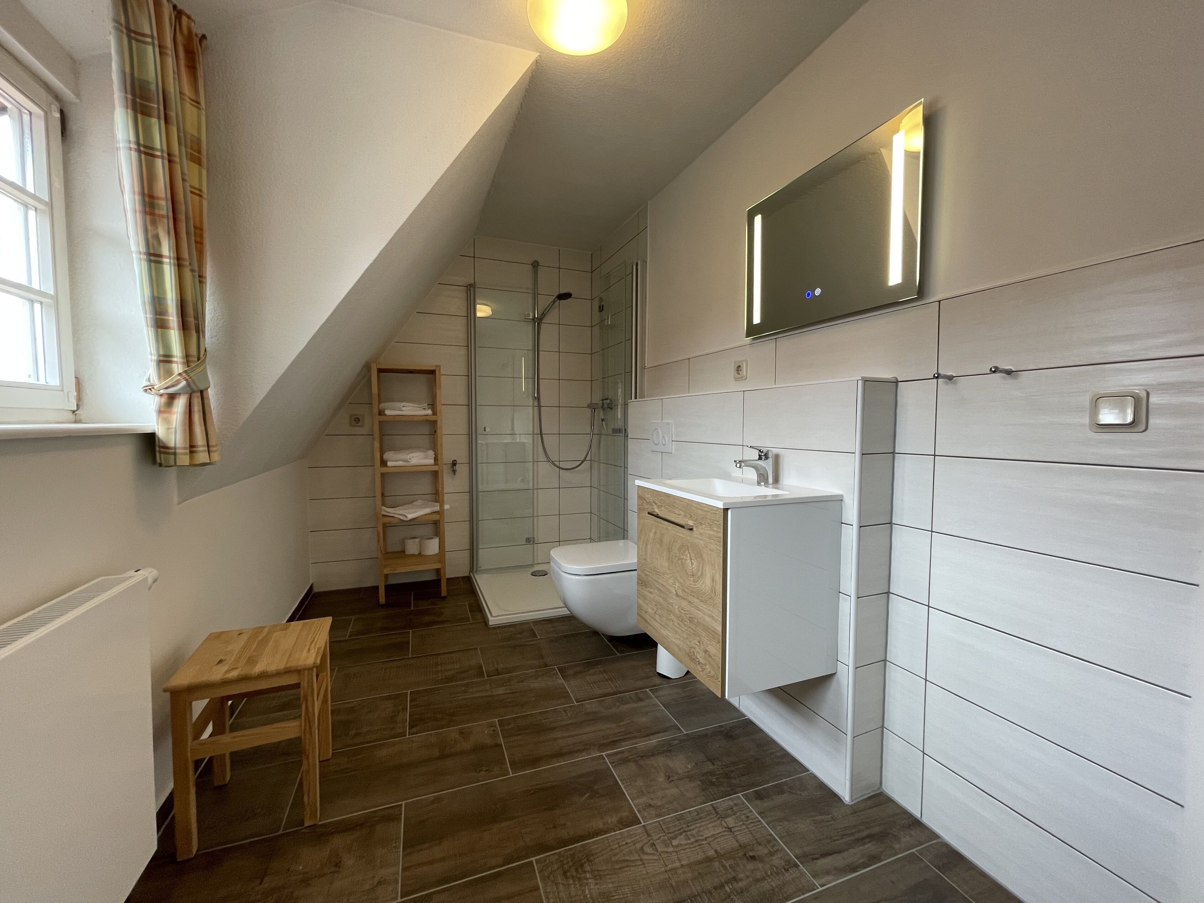 A modern bathroom with a shower, toilet, and sink.