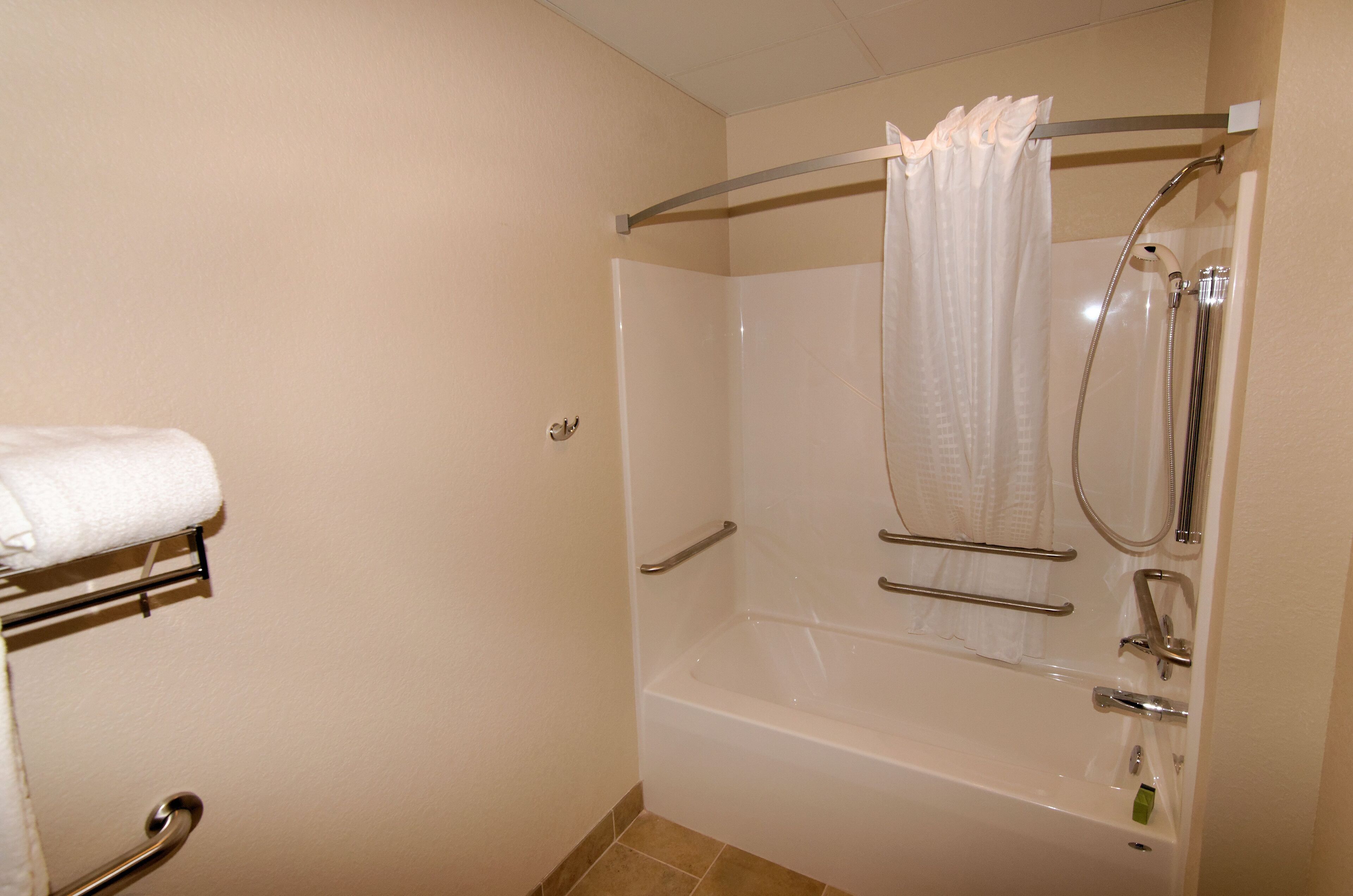A bathroom with a bathtub, a shower, and a towel rack.