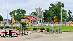 Un parque infantil con toboganes y mesas de picnic.