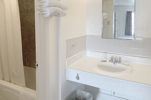 A bathroom with a white sink, a mirror, and a shower curtain.
