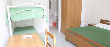 A bedroom with a bunk bed, a single bed, a wooden wardrobe, a table, and a chair.