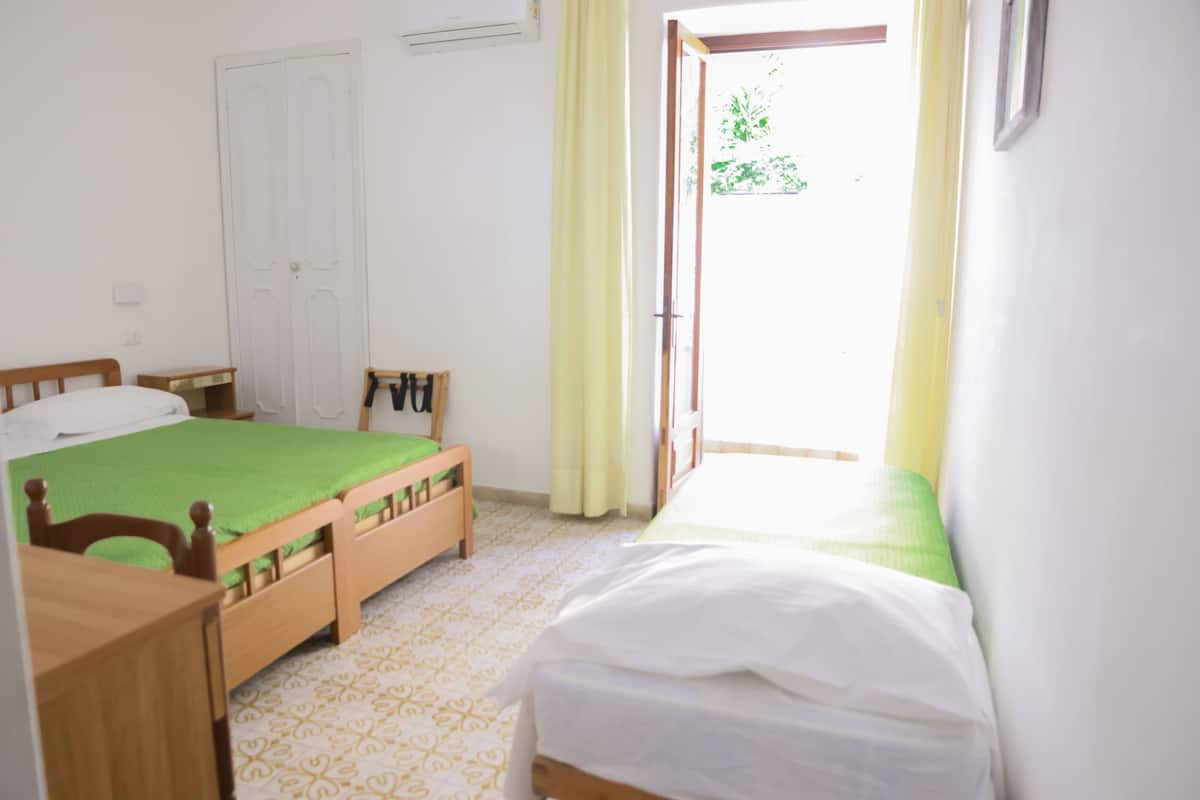 Un dormitorio con dos camas, un escritorio de madera y una puerta.