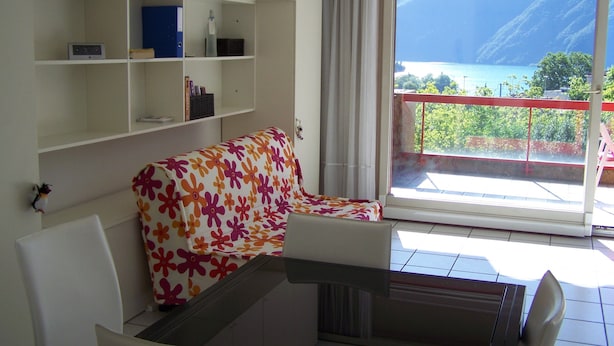Una sala de estar con un sofá, una mesita y un balcón con vistas al mar.