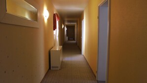 A narrow, carpeted hallway with a light fixture and a towel rack on the left wall. - Acron Traben-Trarbach (Traben-Trarbach)
