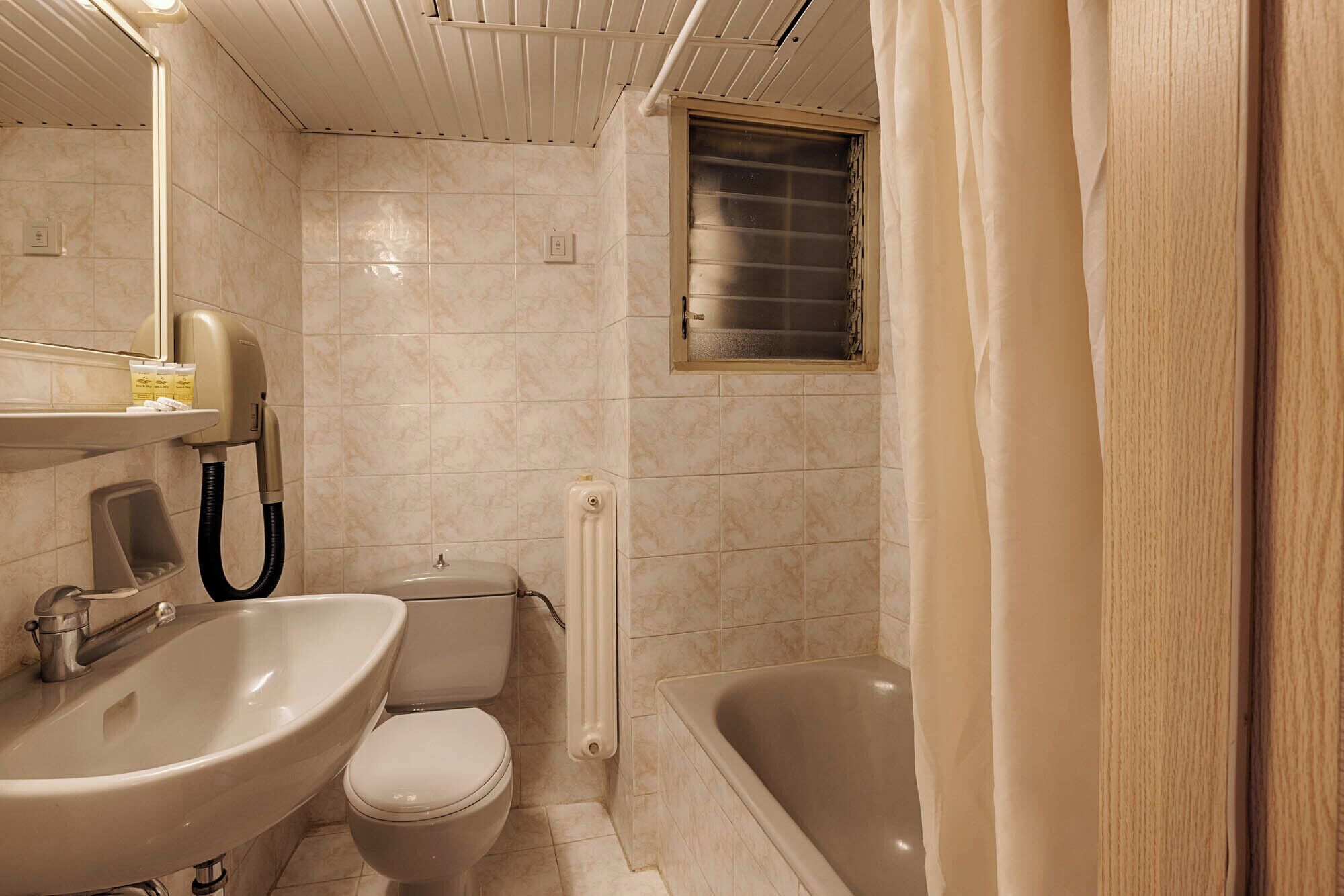 Une salle de bain avec un lavabo, des toilettes et une baignoire.