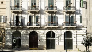 A multi-story building with balconies, large windows, and a storefront at the ground level. - Principe di Belmonte (Palermo)