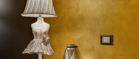 A room with a lamp, a coffee pot, and two cups on a tray.