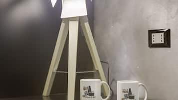 Deux tasses blanches ornées d’un motif inspiré d’un film, posées sur une table à côté d’un trépied.