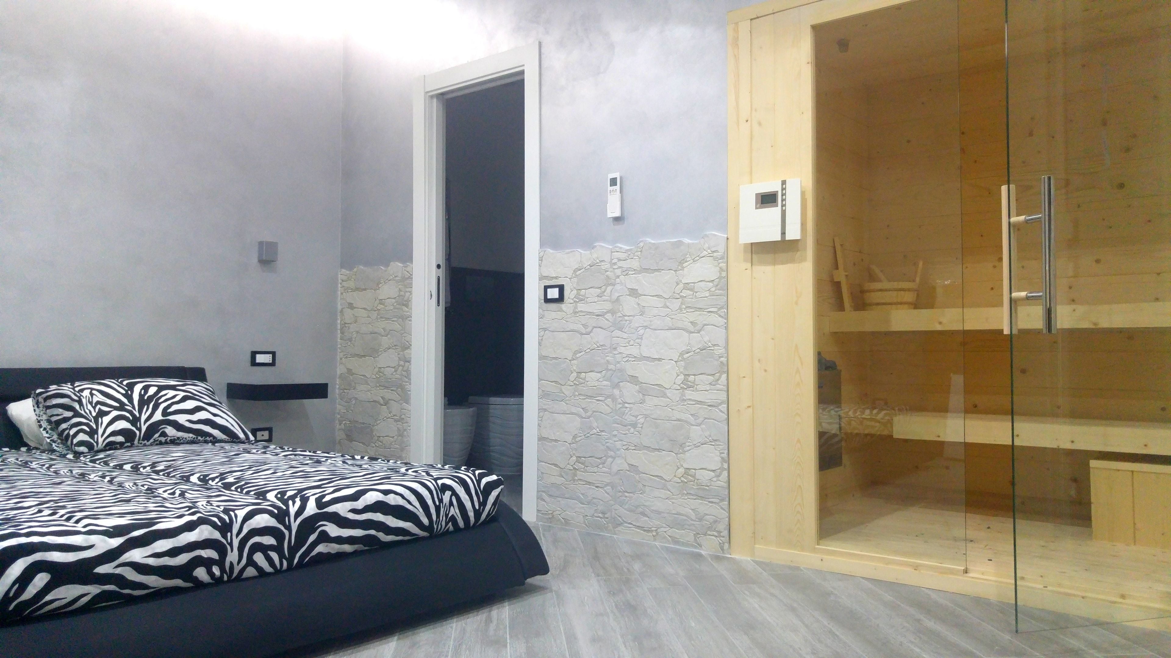 Une chambre à coucher avec un lit, une armoire en bois et un mur en pierre.