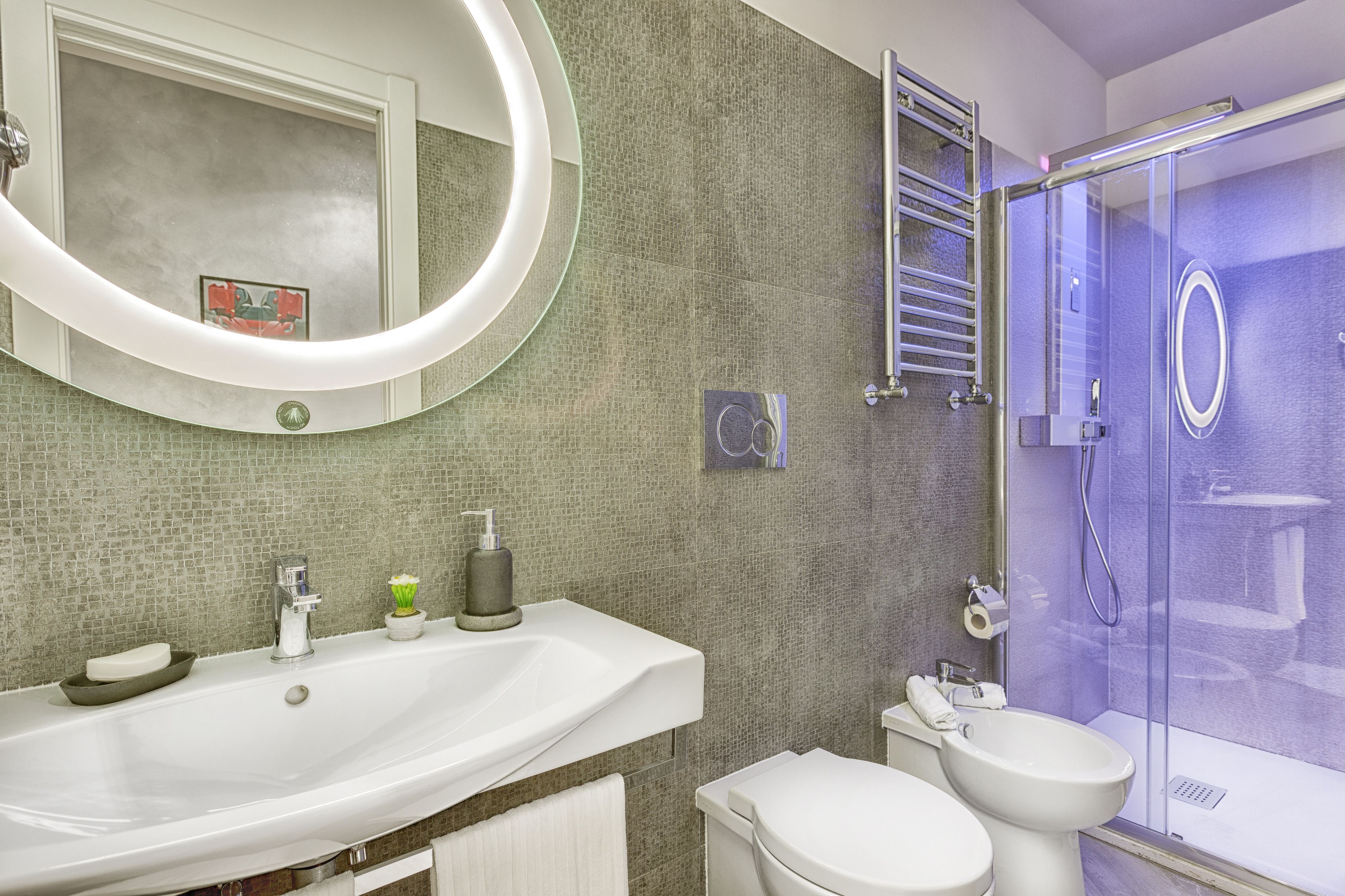 Un baño moderno con un lavamanos grande, inodoro y cabina de ducha de vidrio.