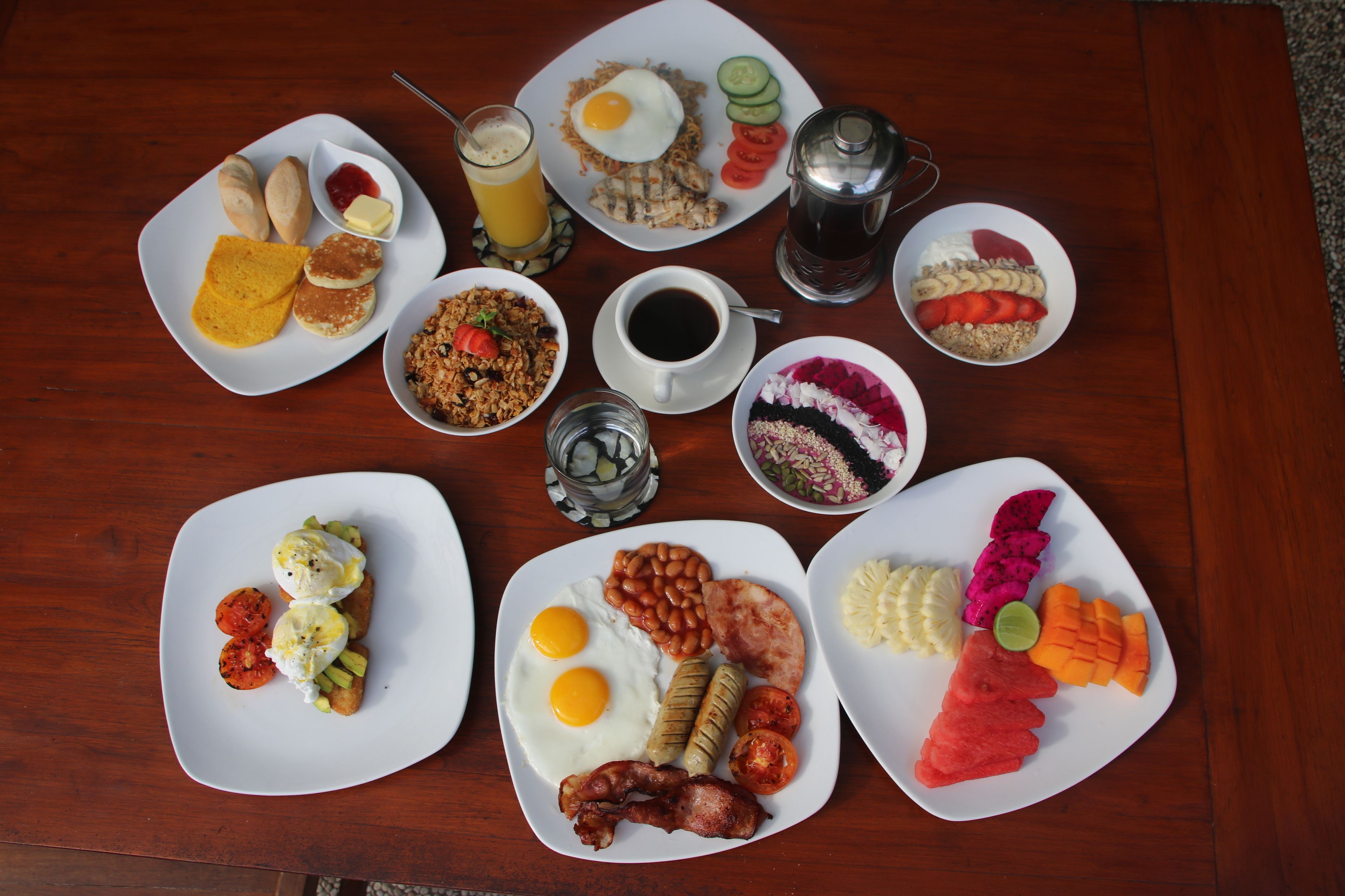 A variety of breakfast dishes on a wooden table.