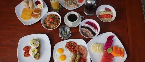 A variety of breakfast dishes on a wooden table.