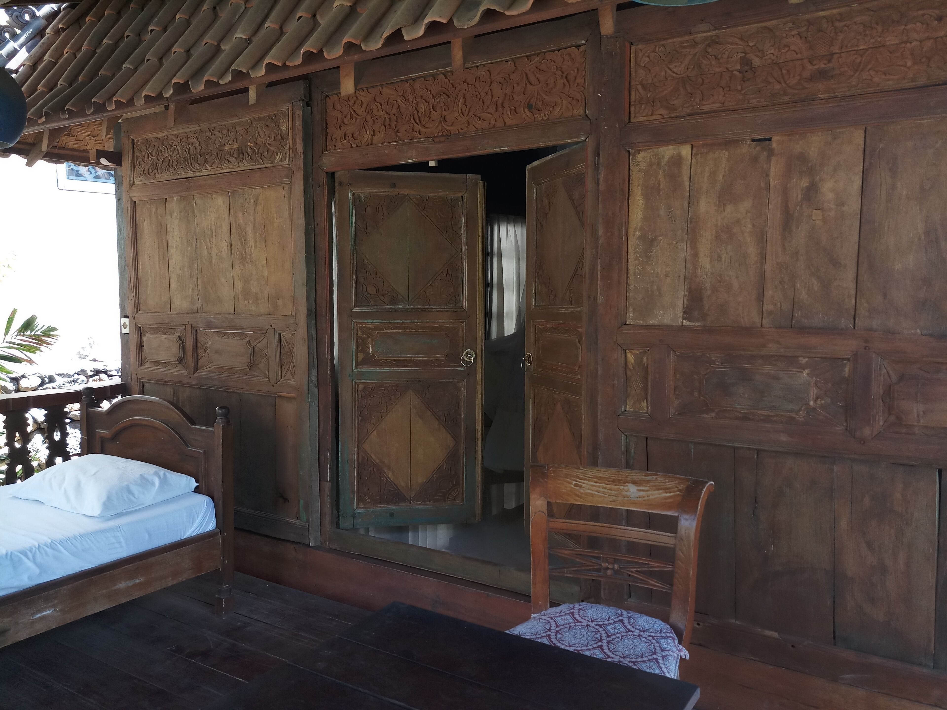 Una habitación de madera con una cama, una mesa y una silla.
