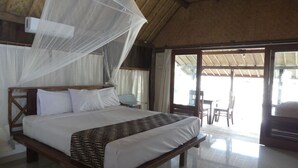 Un dormitorio amplio con una cama grande, mosquitero y vistas al exterior.